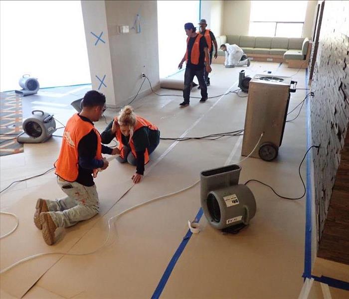 Team members working in orange vests.