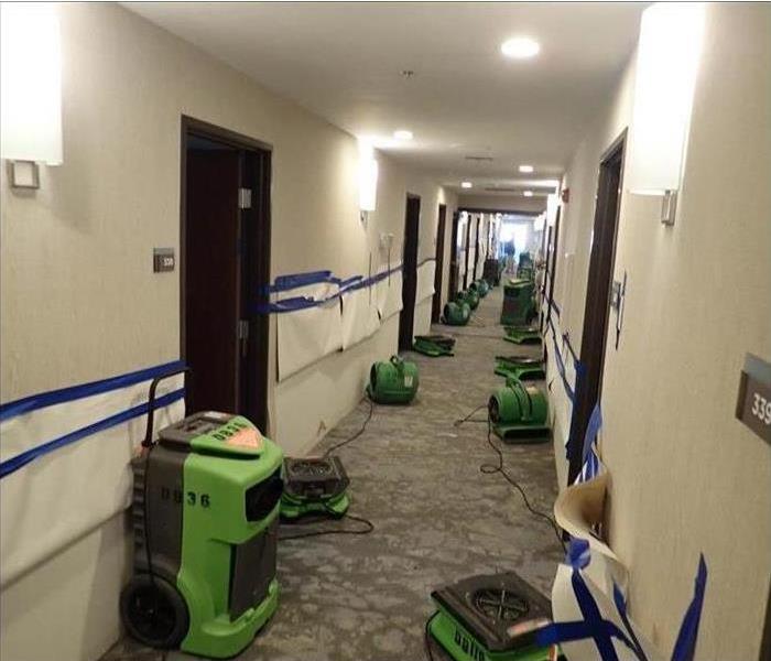 Hallway of a building with air movers and drying equipment